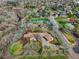 Expansive aerial view of home nestled among trees, featuring a long driveway and well-maintained landscaping at 11489 W Bear Creek Dr, Lakewood, CO 80227
