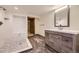 Modern bathroom featuring a walk-in shower with marble, updated vanity, and stylish wood-look tile flooring at 11489 W Bear Creek Dr, Lakewood, CO 80227