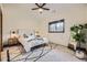 Bright bedroom featuring a ceiling fan, patterned carpet, and a large window allowing for plenty of natural light at 11489 W Bear Creek Dr, Lakewood, CO 80227