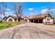 Spacious single-story home featuring a large driveway, attached garages, and a well-maintained lawn at 11489 W Bear Creek Dr, Lakewood, CO 80227