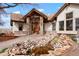 Inviting home exterior showcasing a stone entrance with a koi pond and meticulously kept landscaping at 11489 W Bear Creek Dr, Lakewood, CO 80227