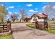 Charming exterior featuring a gated driveway, brick accents, and an American flag waving proudly at 11489 W Bear Creek Dr, Lakewood, CO 80227