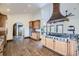 Kitchen features a center island cooktop, stainless appliances, wood cabinets, and hardwood flooring at 11489 W Bear Creek Dr, Lakewood, CO 80227