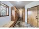 Mudroom featuring tile flooring, wood storage cabinets, a bench, and a window at 11489 W Bear Creek Dr, Lakewood, CO 80227