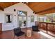 Covered porch with vaulted ceilings, wood floors, comfortable seating, and expansive outdoor views at 11489 W Bear Creek Dr, Lakewood, CO 80227