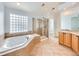 Bright bathroom with a soaking tub, glass-enclosed shower, and ample cabinet space at 7447 Soapstone Way, Castle Rock, CO 80108