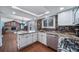 Charming kitchen with granite countertops, stainless steel appliances, and cozy breakfast bar at 18263 E Berry Dr, Centennial, CO 80015