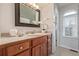 Bathroom vanity featuring a wooden cabinet, sink, and a decorative mirror above, with an arched window in the background at 116 S Lindsey St, Castle Rock, CO 80104