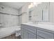 Bathroom featuring a tub with marble tile surround, and vanity with a marble countertop and modern lighting at 116 S Lindsey St, Castle Rock, CO 80104