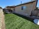 The backyard includes an artificial lawn and a covered patio area with a natural stone trim along the house at 785 Century Ln, Monument, CO 80132