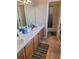 Well-lit bathroom featuring double sinks with a wood vanity and a tiled shower/bathtub combination behind an open door at 785 Century Ln, Monument, CO 80132