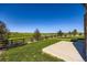 Expansive backyard with lush green lawn, concrete patio, and a rustic wooden fence overlooking rolling hills at 960 Promontory Cir, Elizabeth, CO 80107