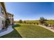 Beautifully landscaped backyard featuring lush green lawn, mature trees, and a stone pathway leading to the home at 960 Promontory Cir, Elizabeth, CO 80107