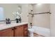 Bright bathroom featuring wood vanity with stone countertop and bathtub with tiled shower at 960 Promontory Cir, Elizabeth, CO 80107