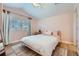 Pink bedroom with hardwood floors, a ceiling fan, and natural sunlight from the windows at 960 Promontory Cir, Elizabeth, CO 80107