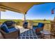 Inviting outdoor deck with wicker seating, blue cushions, and stunning views of the surrounding landscape at 960 Promontory Cir, Elizabeth, CO 80107