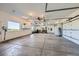 Spacious three car garage with bright lighting, white walls, and large window with a lush green view at 960 Promontory Cir, Elizabeth, CO 80107