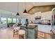 Well-lit kitchen with pendant lights, stainless steel appliances, modern backsplash, and an adjacent dining area at 960 Promontory Cir, Elizabeth, CO 80107