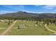 Aerial view of the home, outbuildings and land with mountain in background at 11173 Emerald Ln, Conifer, CO 80433