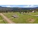 Aerial view of the home, outbuildings, surrounding land and mountain views at 11173 Emerald Ln, Conifer, CO 80433