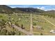 Expansive aerial view showing homes in a green valley community, trees and open meadows at 11173 Emerald Ln, Conifer, CO 80433