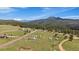 Scenic aerial view of a beautiful mountain community with green pastures and trees at 11173 Emerald Ln, Conifer, CO 80433
