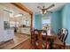 Cozy dining room with a wooden table, ceiling fan, and a view into the kitchen with white cabinetry at 11173 Emerald Ln, Conifer, CO 80433