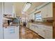Bright kitchen featuring white cabinetry, tan countertops, tile flooring, and stainless steel appliances at 11173 Emerald Ln, Conifer, CO 80433