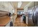 Spacious kitchen with adjoining dining room and living room view, featuring tiled floors and white cabinets at 11173 Emerald Ln, Conifer, CO 80433