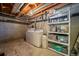 Basement laundry area with washer, dryer, shelving and concrete walls at 11173 Emerald Ln, Conifer, CO 80433