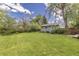 Spacious backyard featuring lush green grass, mature trees, a storage shed and a fence at 270 31St St, Boulder, CO 80305