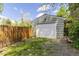 Garage with white door, fenced yard, and vibrant greenery in a natural setting at 270 31St St, Boulder, CO 80305