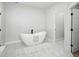 Elegant bathroom with a freestanding tub, marble tile flooring, and contemporary fixtures, creating a relaxing oasis at 61800 E 32Nd Ct, Strasburg, CO 80136