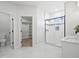 Bright and spacious bathroom with a glass-enclosed shower, double vanity, and a view into the walk-in closet at 61800 E 32Nd Ct, Strasburg, CO 80136