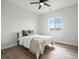 This bedroom has wood flooring, a ceiling fan, and a bed with a grey and white blanket at 61800 E 32Nd Ct, Strasburg, CO 80136