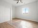 Bedroom featuring wood floors, a closet, a ceiling fan with light and a window to the outside at 61800 E 32Nd Ct, Strasburg, CO 80136