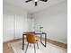 Neutral home office boasts wood floors, a modern desk with chair and a ceiling fan with light at 61800 E 32Nd Ct, Strasburg, CO 80136