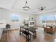 Bright open-concept dining area boasts wood floors, modern lighting, fireplace and views of the surrounding landscape at 61800 E 32Nd Ct, Strasburg, CO 80136