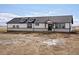 The home's exterior features black trim, dormer windows, a stone foundation, and ample land at 61800 E 32Nd Ct, Strasburg, CO 80136
