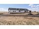Exterior showcasing black-trim windows, dormers, stone detail, and expansive landscape at 61800 E 32Nd Ct, Strasburg, CO 80136