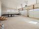 Spacious unfinished garage with multiple garage doors, bright lighting and a trailer at 61800 E 32Nd Ct, Strasburg, CO 80136