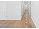Hallway with white walls, doors, and light wood flooring, showcasing the home's layout at 61800 E 32Nd Ct, Strasburg, CO 80136