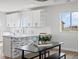 Bright kitchen with white cabinets, quartz countertops, and view of the field outside at 61800 E 32Nd Ct, Strasburg, CO 80136