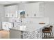 Modern kitchen featuring white cabinetry, stainless steel appliances, and a stylish breakfast bar at 61800 E 32Nd Ct, Strasburg, CO 80136