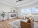 Bright living area with brick fireplace, contemporary ceiling fan, wood floors and large windows at 61800 E 32Nd Ct, Strasburg, CO 80136