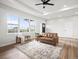 Open-concept living room with plenty of natural light, modern fan, and views of the land at 61800 E 32Nd Ct, Strasburg, CO 80136