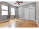 Bright bedroom featuring two windows, hardwood floors, and a double door closet at 2724 Federal Blvd # 2, Denver, CO 80211