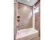 Modern bathroom shower featuring gray tile walls, built in shelves, and bathtub at 2724 Federal Blvd # 2, Denver, CO 80211