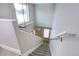 Carpeted staircase featuring neutral walls, modern railing and a window at the top of the landing at 2724 Federal Blvd # 2, Denver, CO 80211