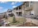 Beautifully landscaped backyard with a stone patio, lush grass, and a stairway leading to the upper deck at 8815 S Tibet Ct, Aurora, CO 80016